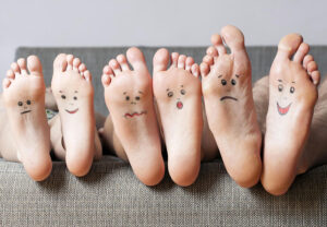 Photo of 3 sets of feet with faces drawn on them